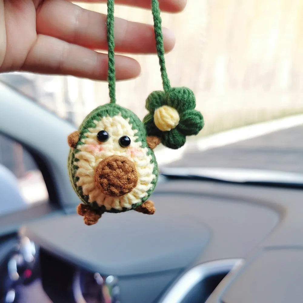 Handmade crocheted avocado-shaped and rainbow pattern car pendants made from wool yarn.