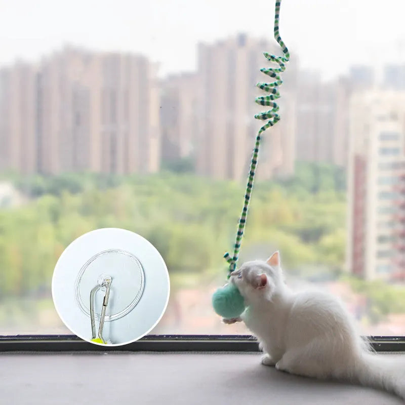 Hanging cat toy with coloured bell stick and inflatable ball attached by suction cup to a door