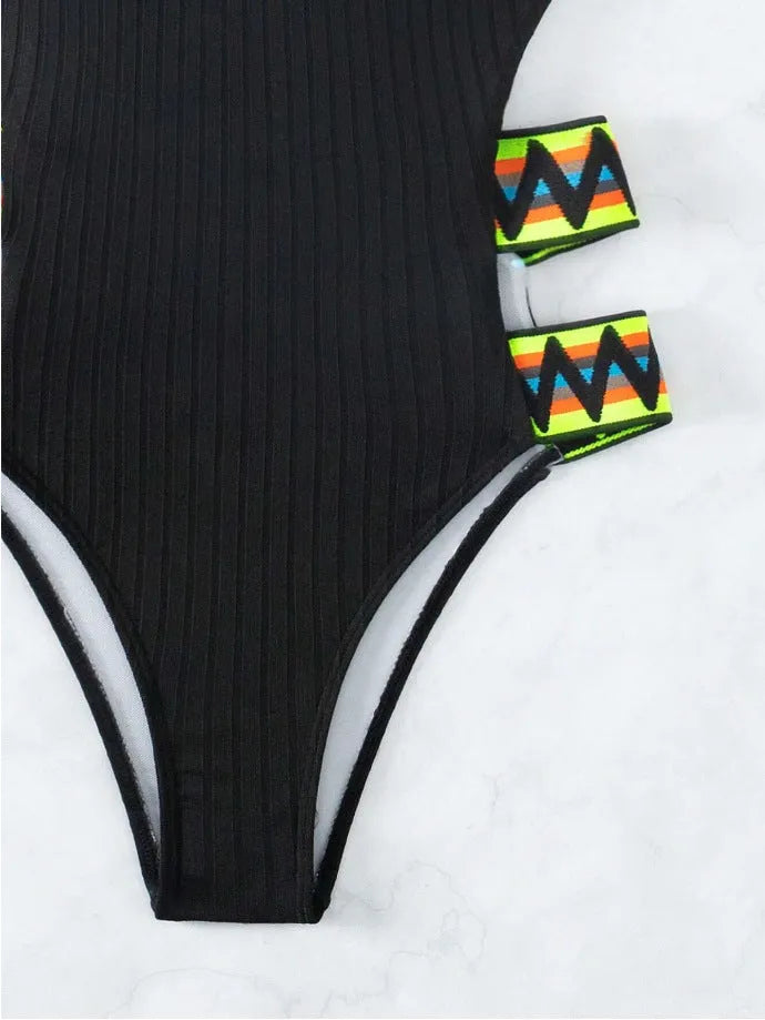 Women's solid black one-piece polyester swimsuit laid flat, showing its simple design.