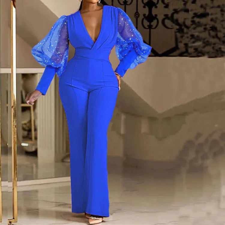 Red women's jumpsuit with mesh stitching on long sleeves, elastic waist, and wide leg trousers.