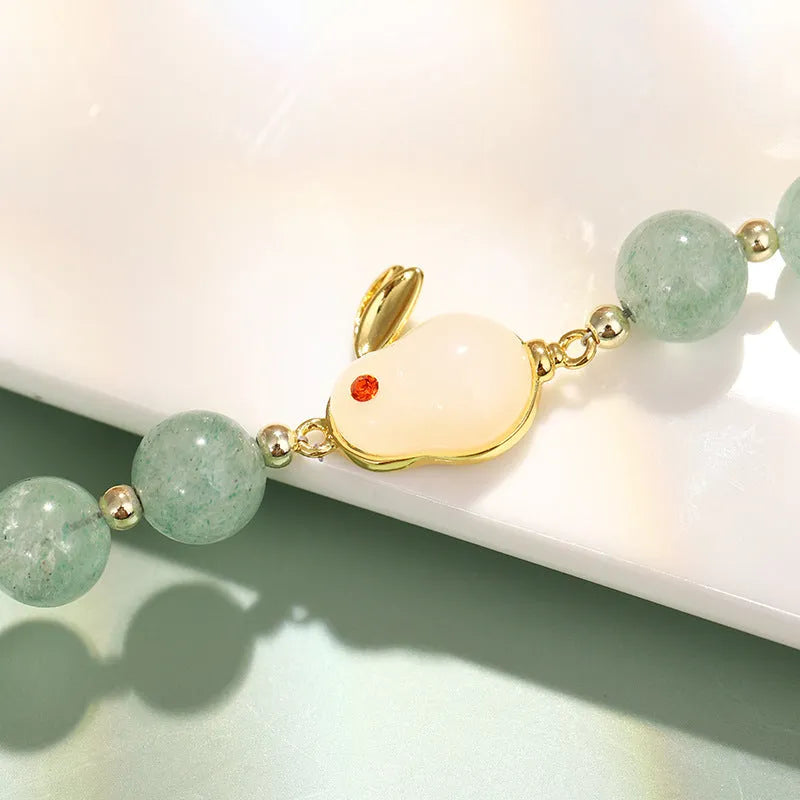 Rabbit charm bracelet with green aventurine and strawberry quartz stones on copper metal with gold accents