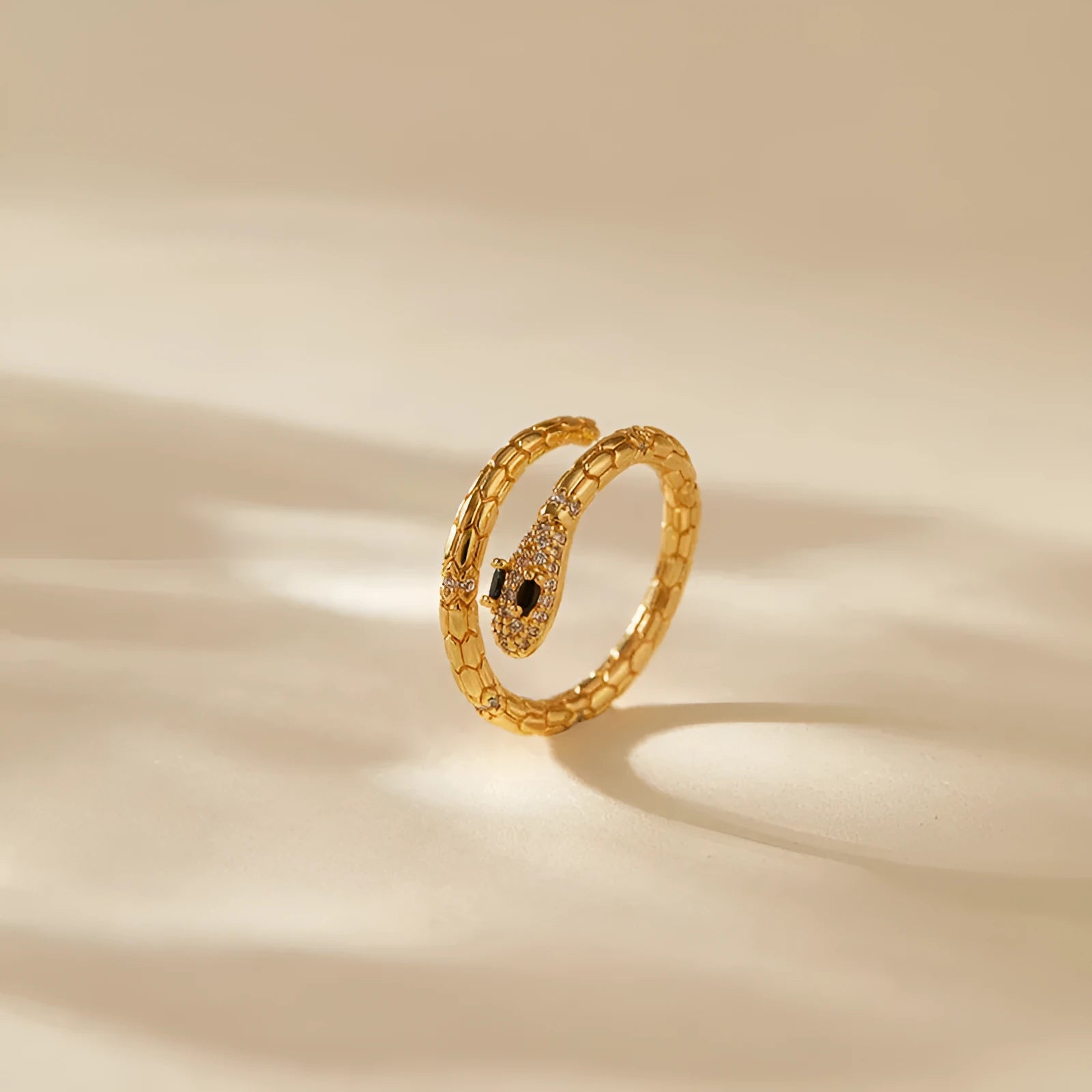Snake-shaped adjustable copper ring with 18K gold colour retention plating on index finger