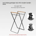 Black folding iron trash storage rack with a wooden handle holding a bin bag.