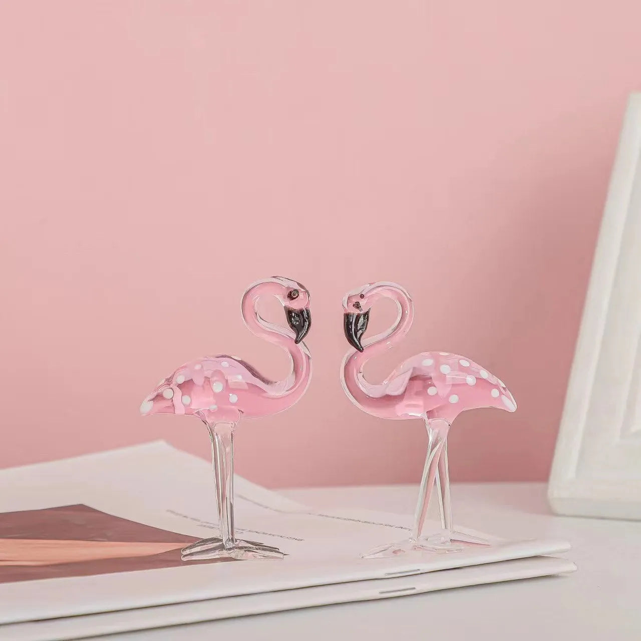 Pink crystal flamingo decorative ornament on a table, modern minimalist style.