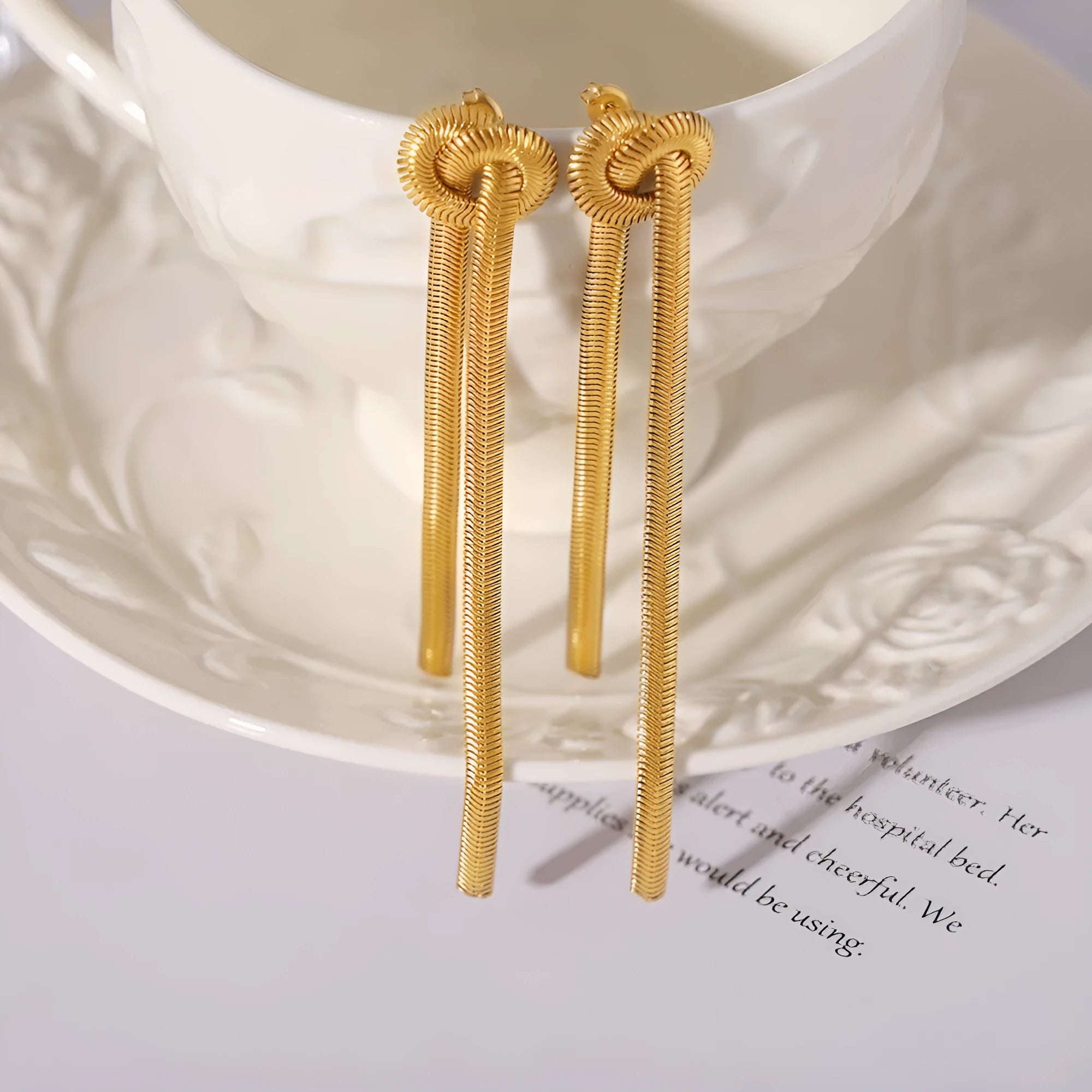 Gold knotted tassel pendant on titanium steel snake chain necklace with matching electroplated earrings
