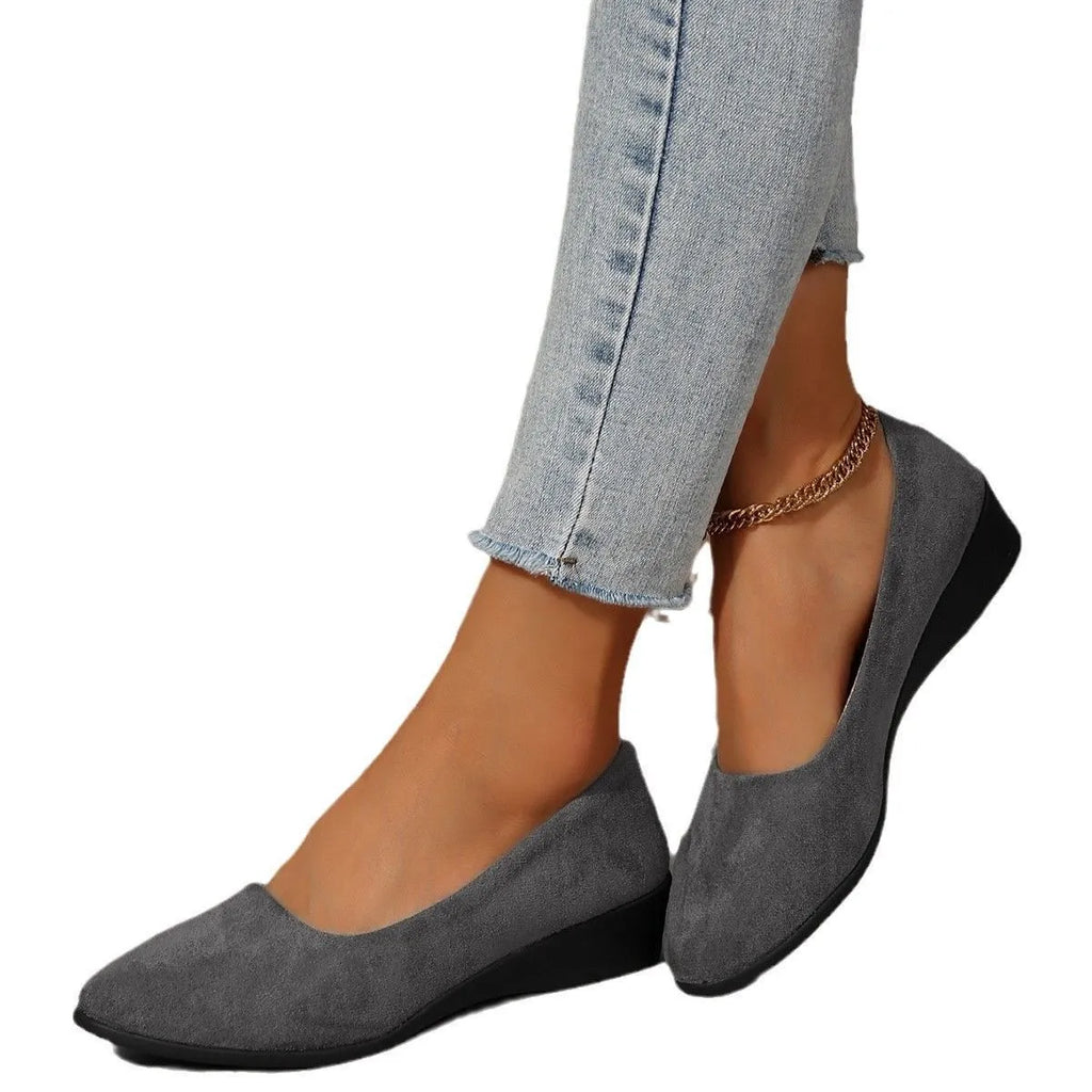 Women's suede wedge pump in light brown with pointed toe and low wedge heel.