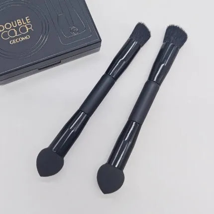 Double-headed concealer brush with tapered bristles and a miter sponge on a long black wooden handle.