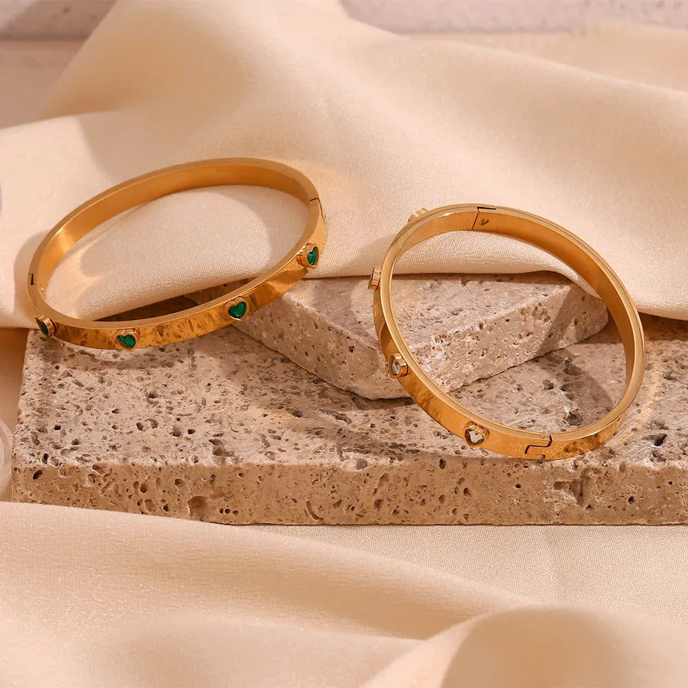 Gold stainless steel women's bracelet with a small micro-inlaid peach heart, shown with green and white diamond accent options.