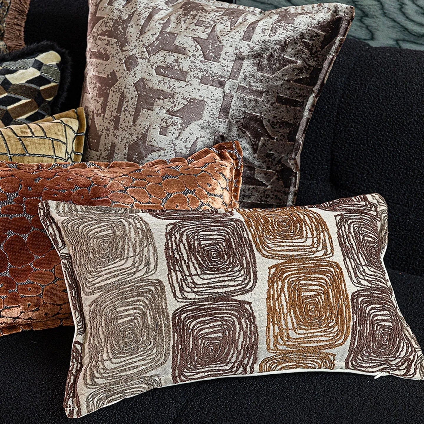 Cream and coffee-coloured abstract coil pattern printed on square polyester velvet pillow cover