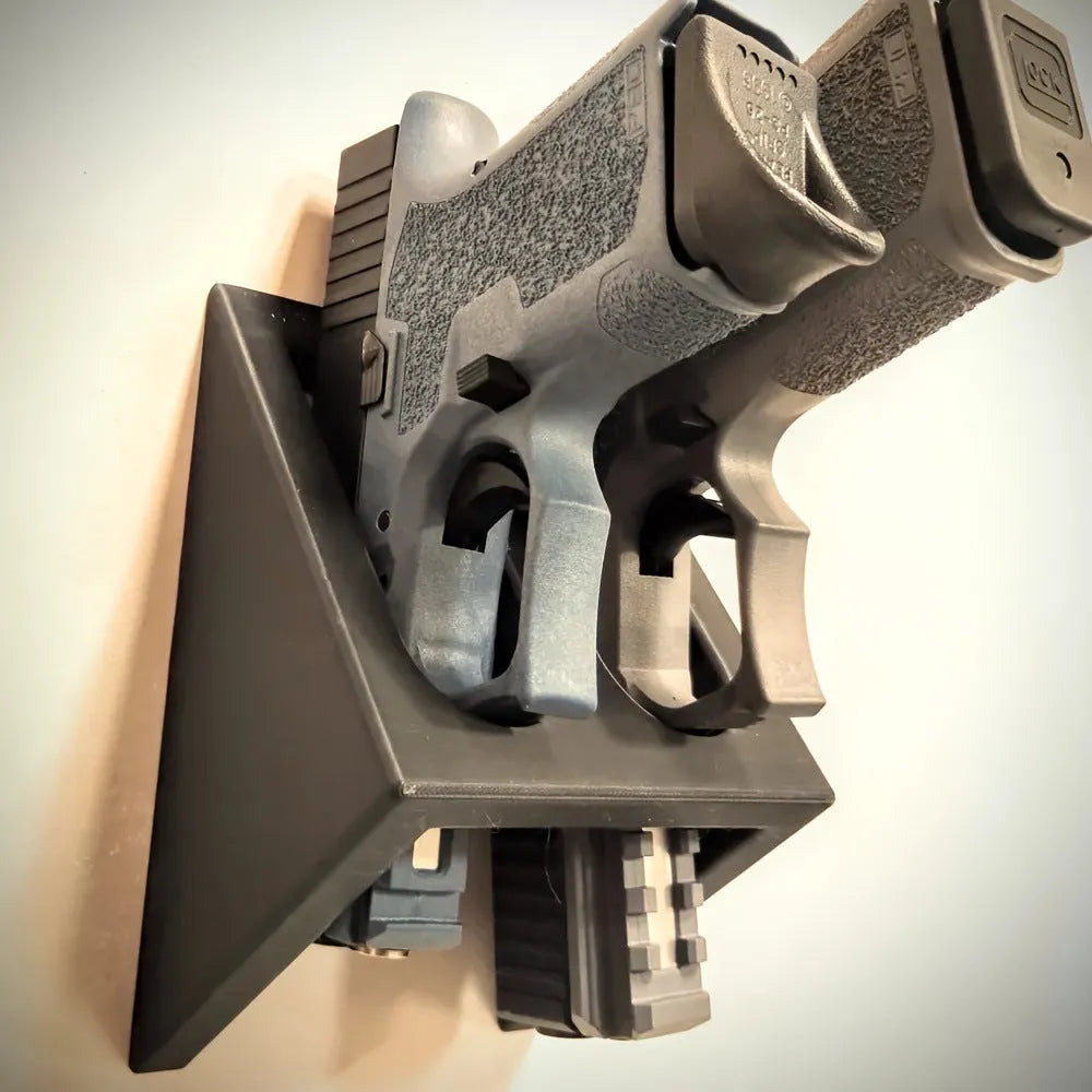 Matte black plastic pistol display stand with a punk-style design on a flat surface.