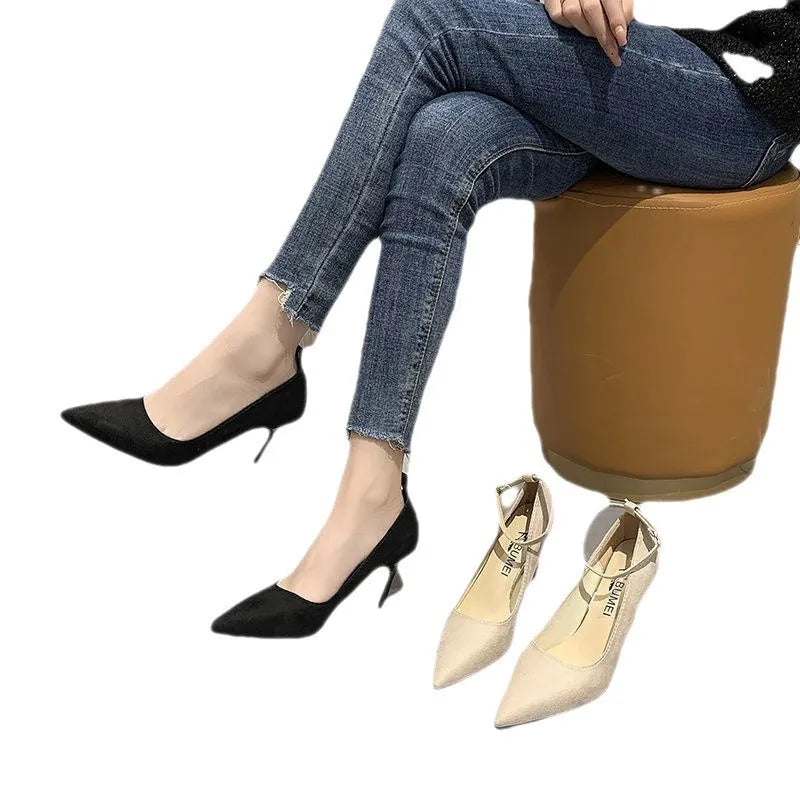 Black and creamy white women's stiletto heel pumps with a skull pattern and ankle buckle.