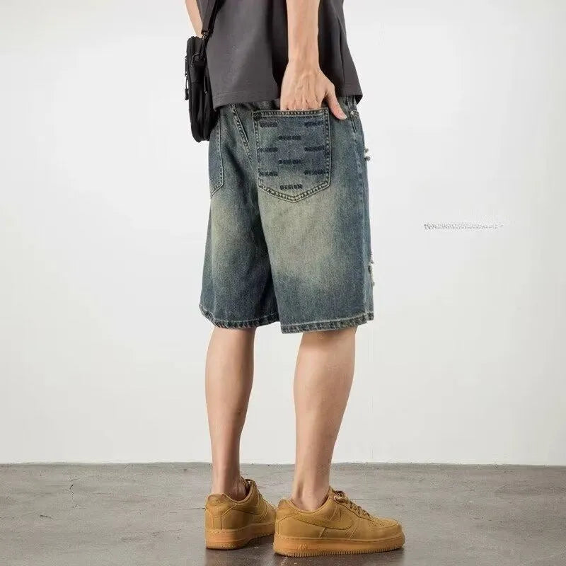 Men's blue retro loose hole denim shorts with a straight leg cut on a neutral background.