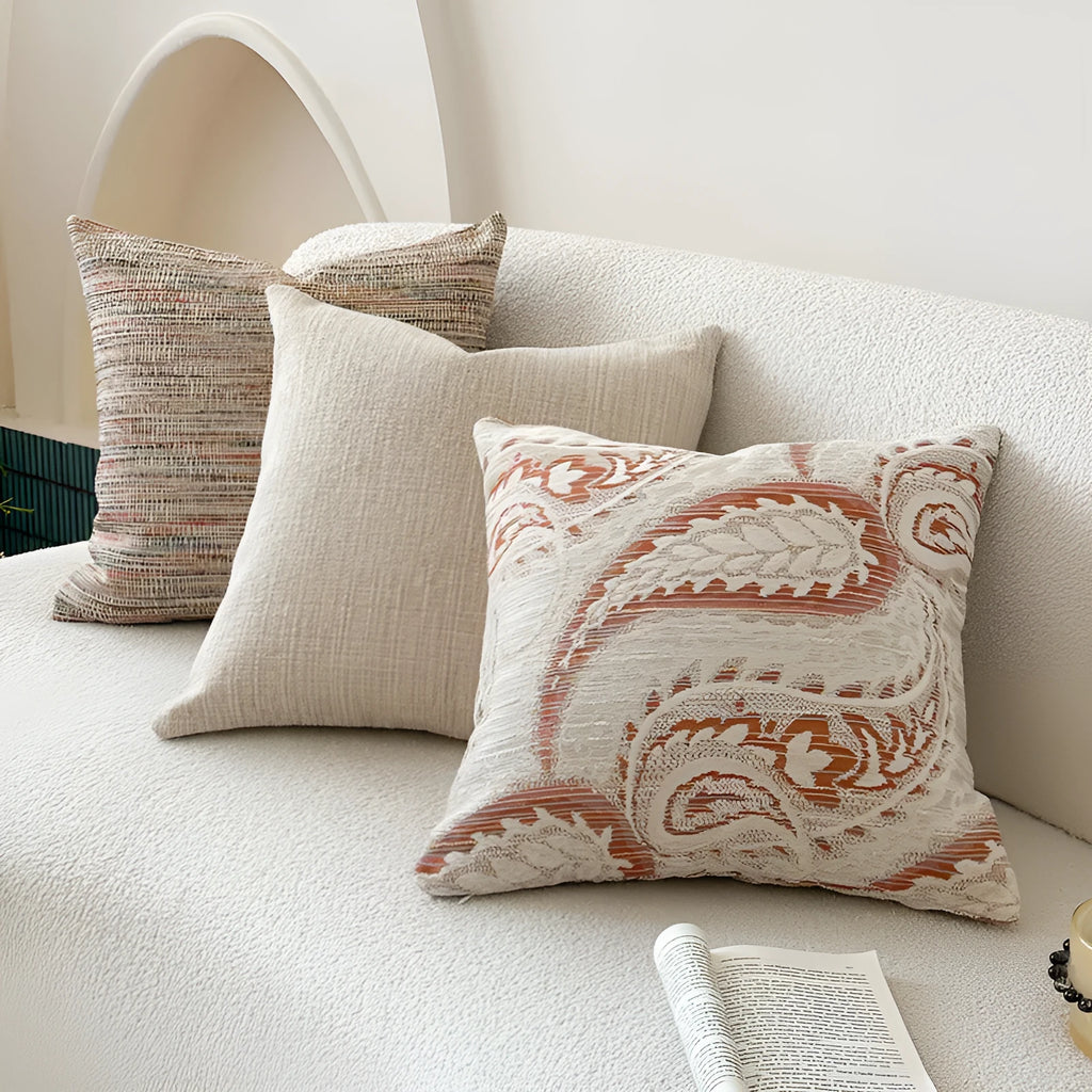 Jacquard woven paisley pattern pillow cover in amber colours on a sofa.