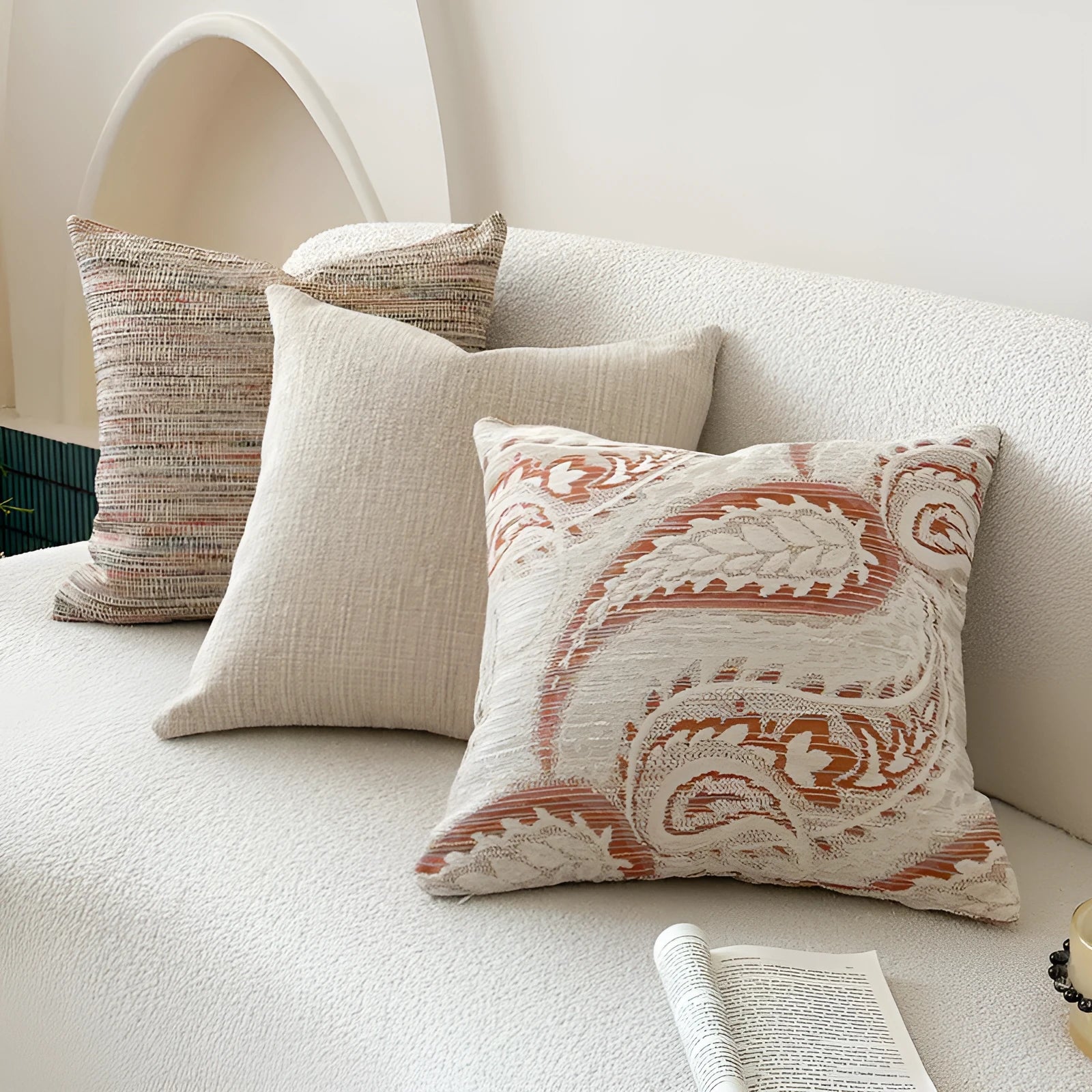 Jacquard woven paisley pattern pillow cover in amber colours on a sofa.