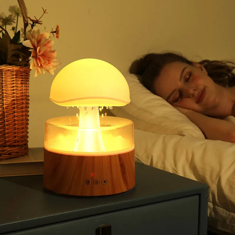 White cloud-shaped humidifier with LED lighting and raindrop simulation on wooden surface