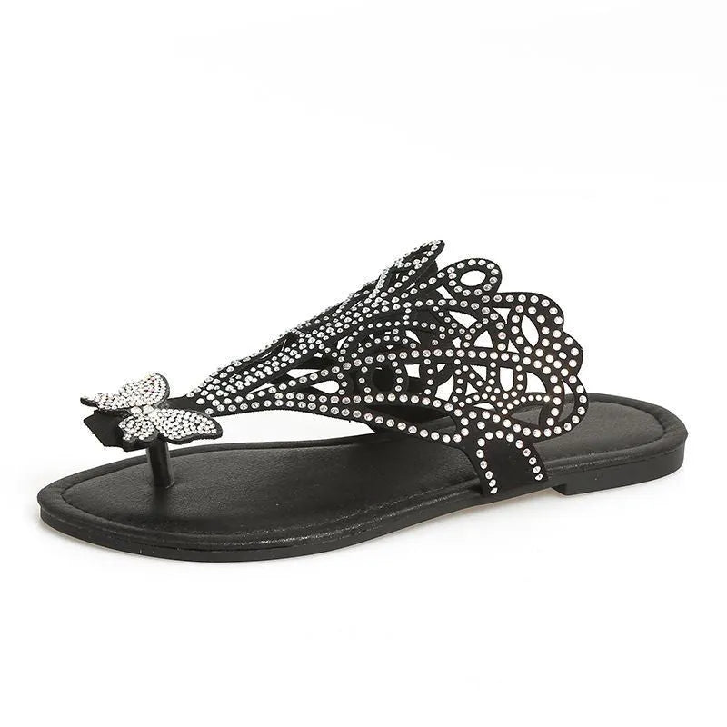 Women's black slip-on sandals with rhinestone details on flip-toe hollow design.