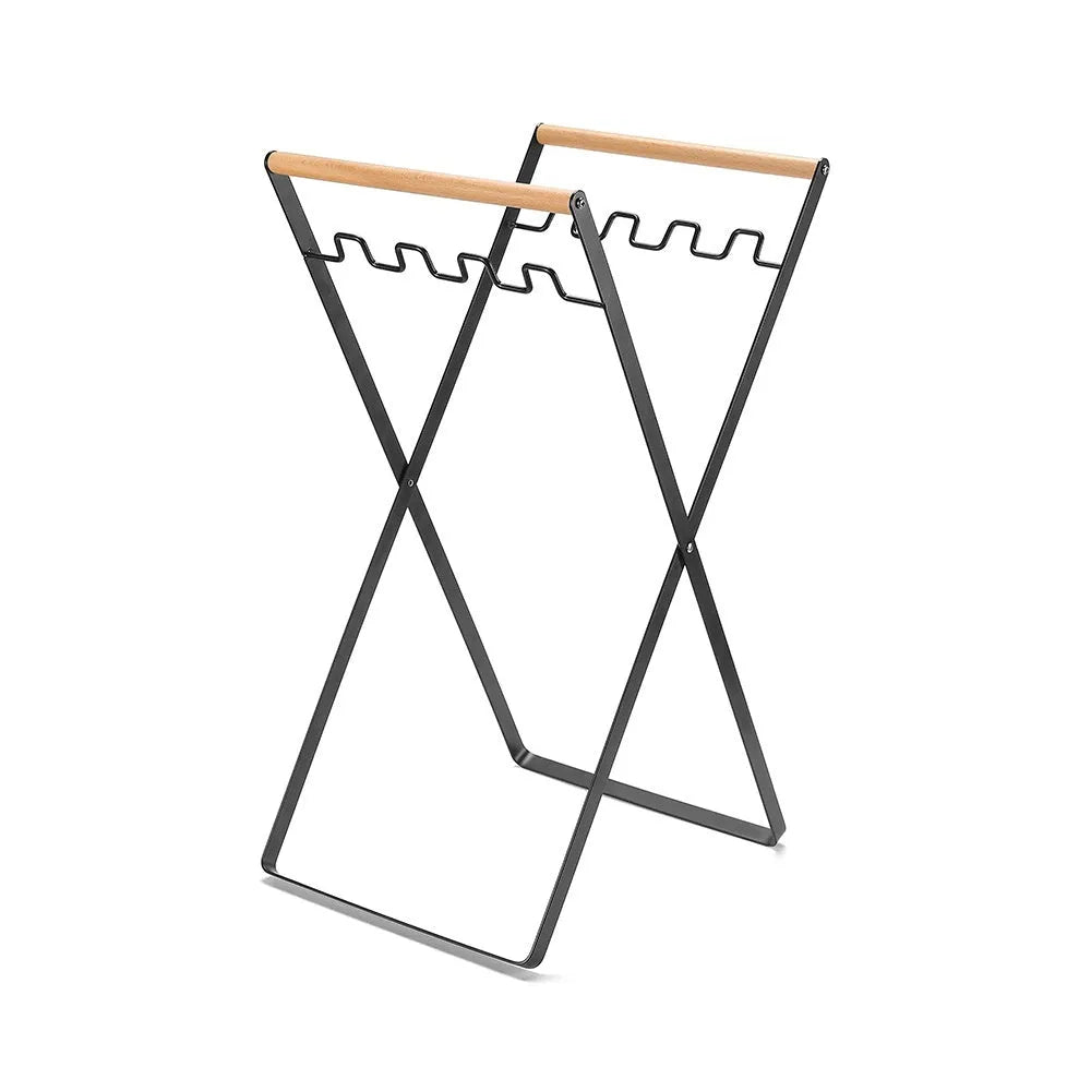 Black folding iron trash storage rack with a wooden handle holding a bin bag.