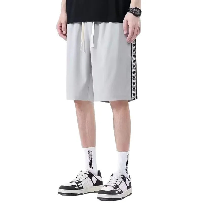 Men's loose-fit black track trousers with an elasticated waistband and baggy leg silhouette.