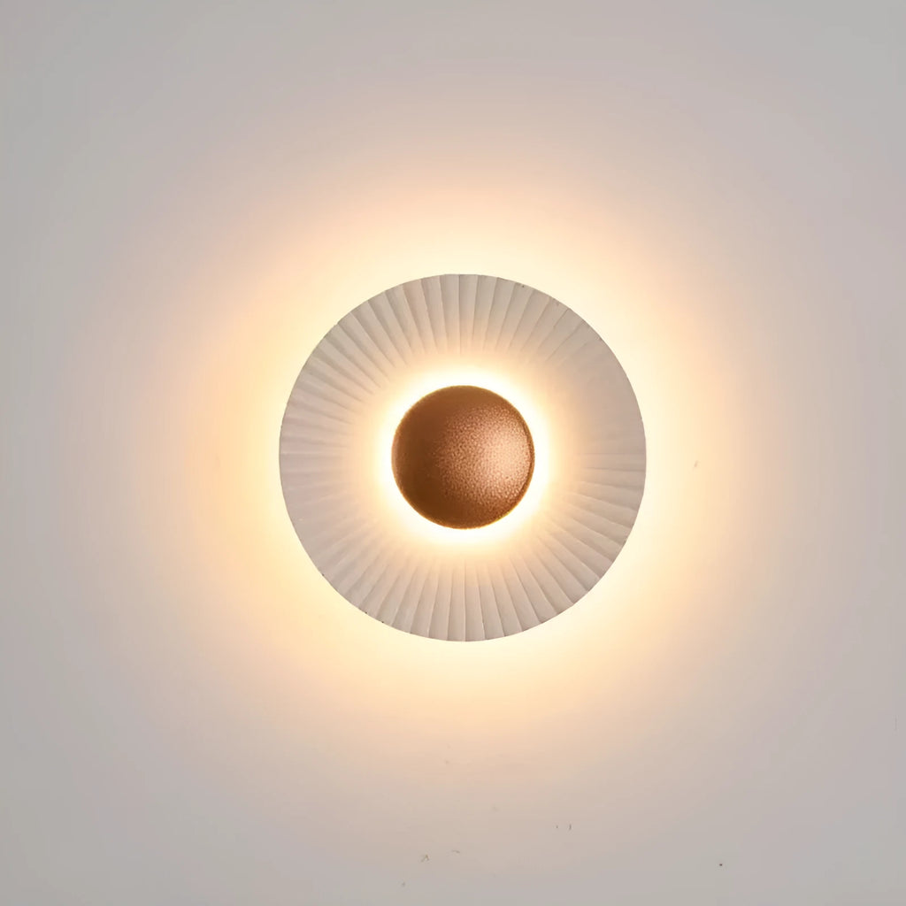 Round white and gold aluminium wall lamp mounted on a wall, LED light source visible.