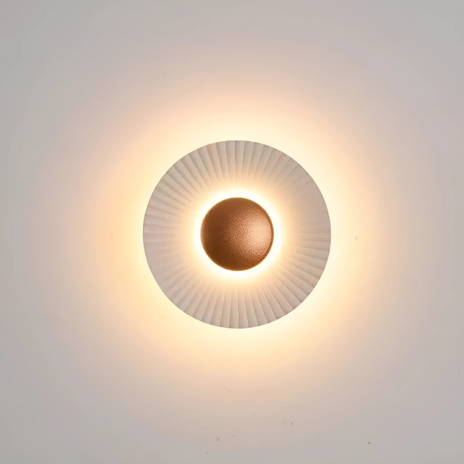 Round white and gold aluminium wall lamp mounted on a wall, LED light source visible.