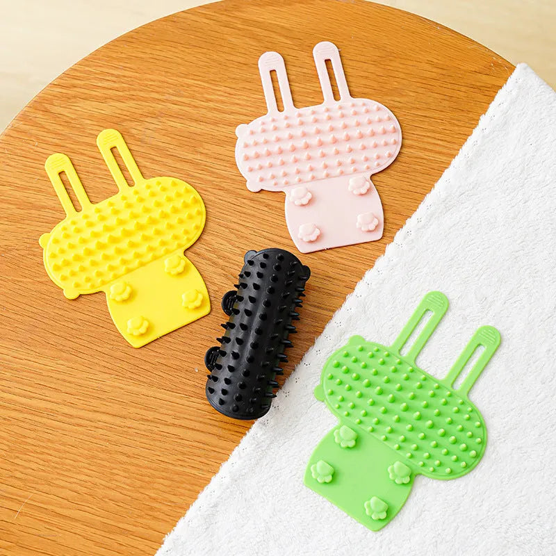 Silicone cat grooming comb with adjustable strap mounted on table leg