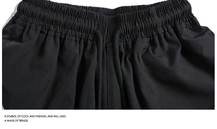 Men's black quick-drying sports shorts with grey contrast panels and elastic waistband