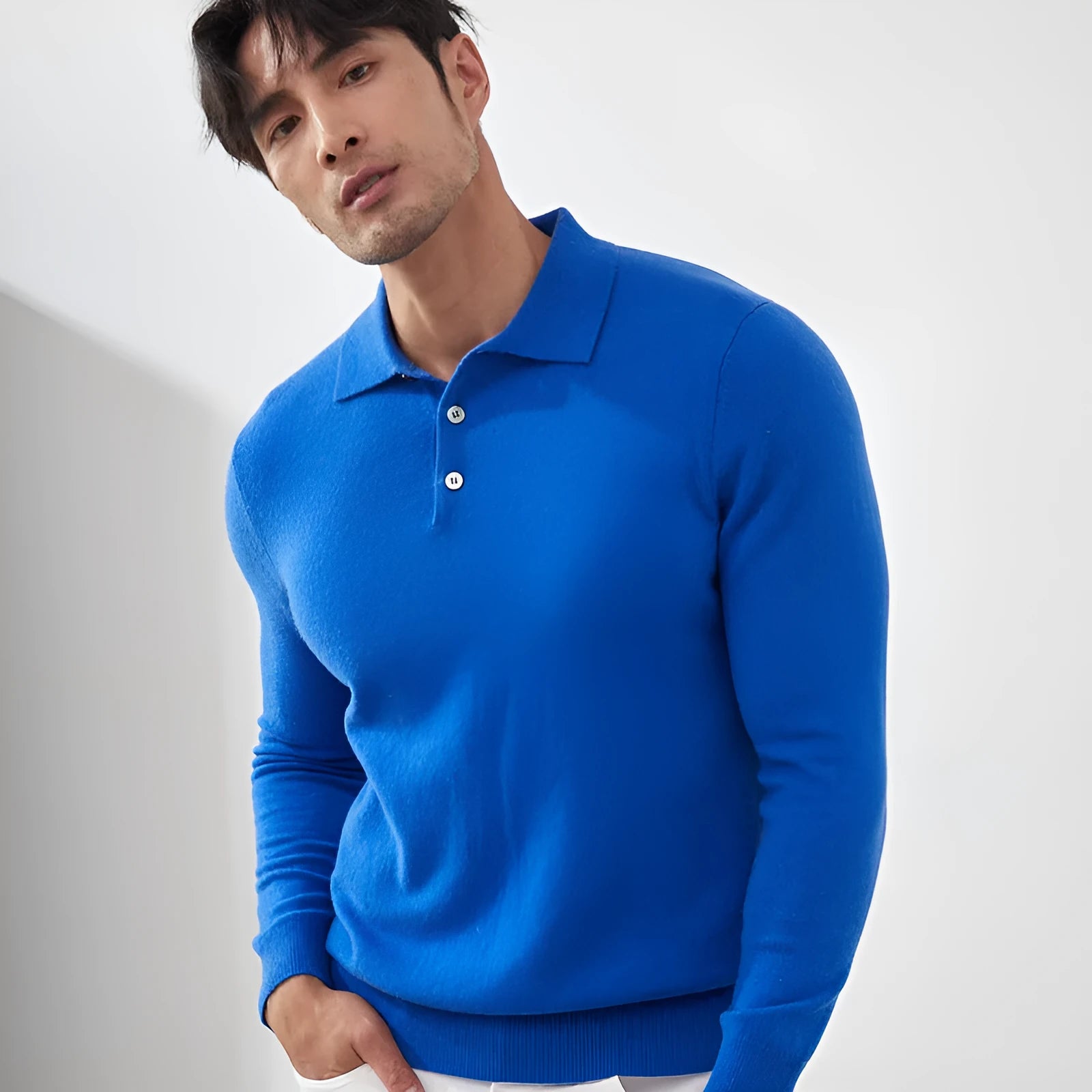 Man wearing a sapphire blue loose-fit cashmere polo collar pullover sweater.
