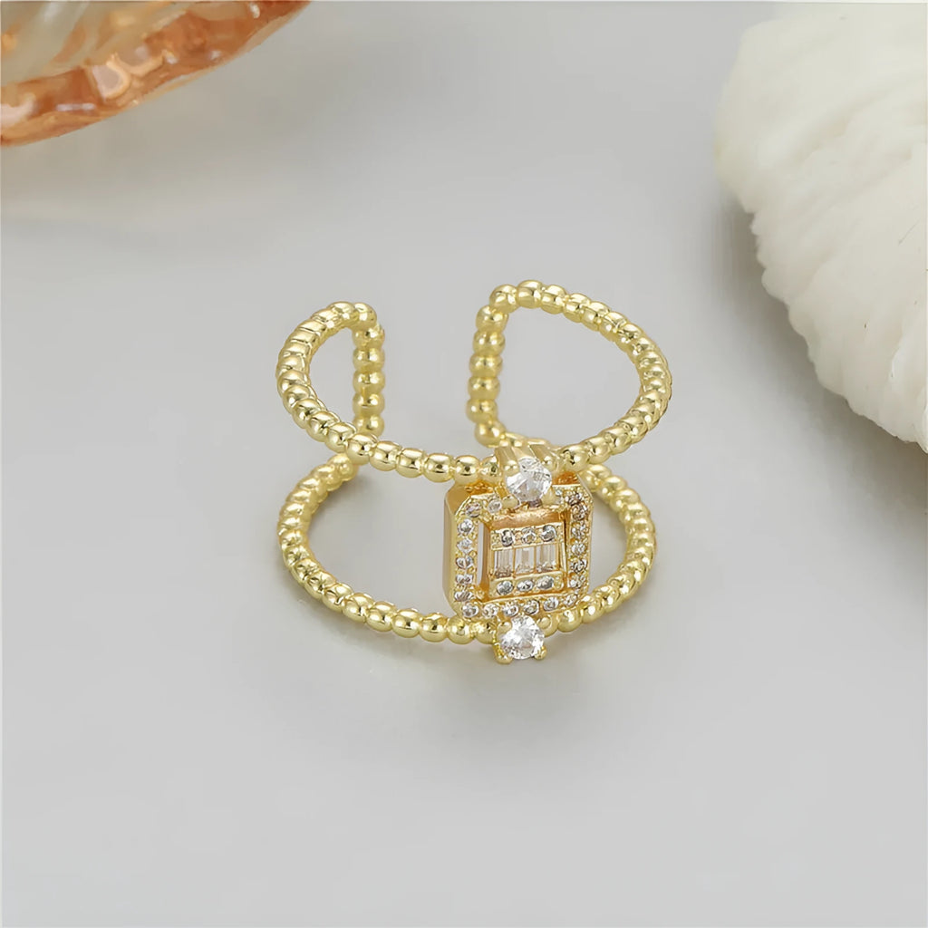 Gold-coloured adjustable open ring with an asymmetric U-shaped design on a plain background.