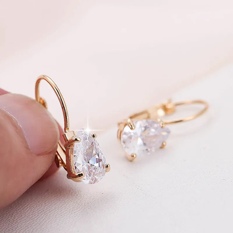 Drop-shaped women's fashion earrings in gold or platinum finish with an inlaid gem