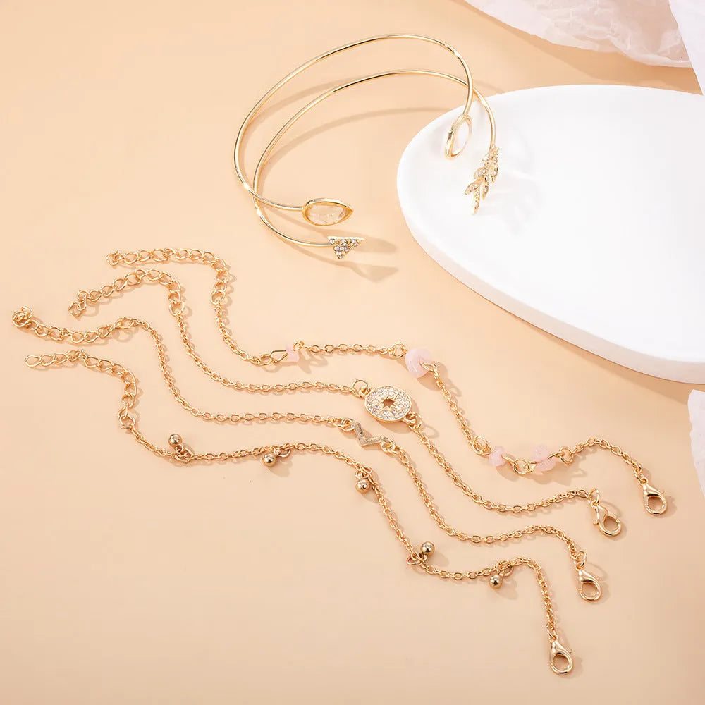 Gold six-piece bracelet charm set with V-shaped, arrow, water drop, and spot drill designs on zinc alloy