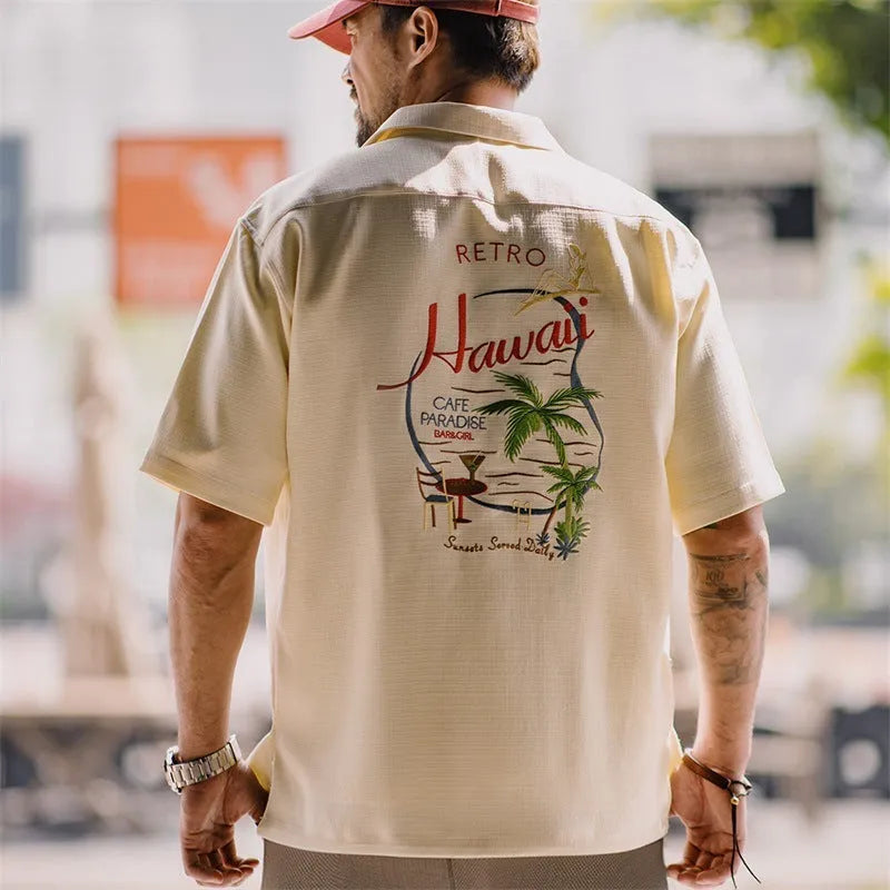 Light apricot coloured men's shirt with a bamboo and floral pattern and a Cuban collar.