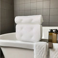 White 3D mesh bathtub pillow with multiple suction cups, shown on a bathtub.