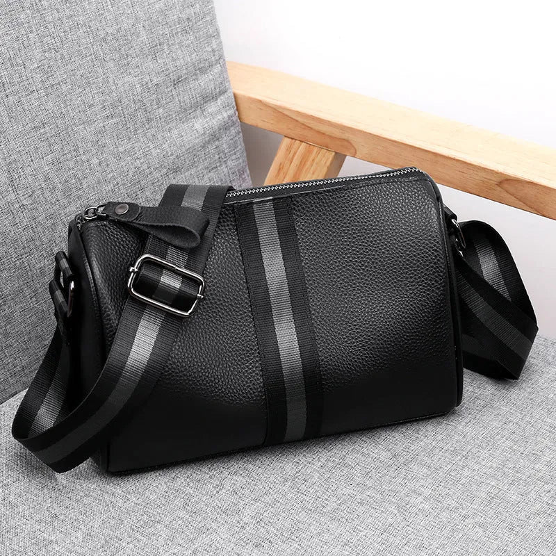 Black genuine leather one-shoulder crossbody bag showing its large size and crossbody strap.