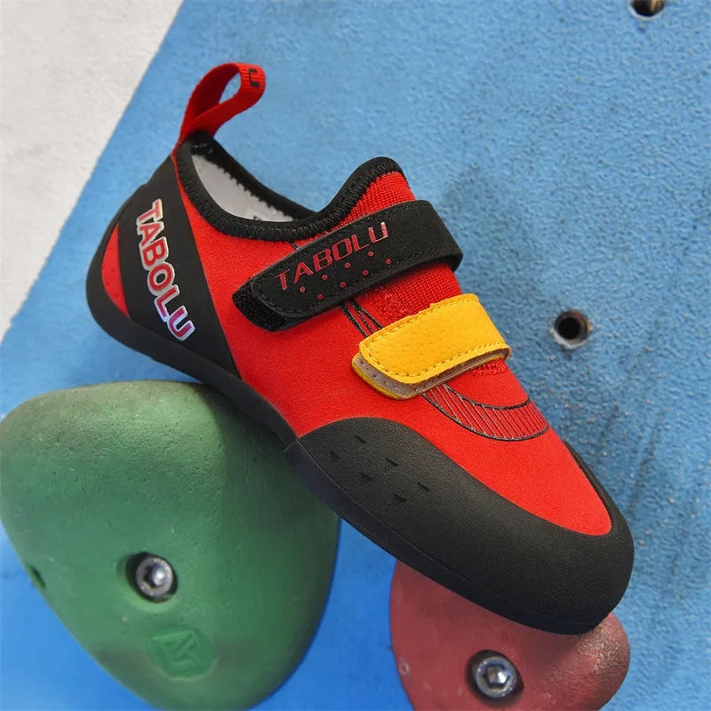 A pair of Velcro closure rock climbing shoes with a non-slip rubber sole in a black and red colour scheme.