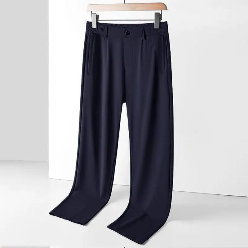 Man wearing black loose-fit straight-leg Ice Silk trousers with an elastic waistband for leisure wear.