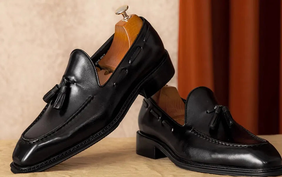 Men's genuine leather slip-on loafers in black and brown with fringed detailing and rubber soles