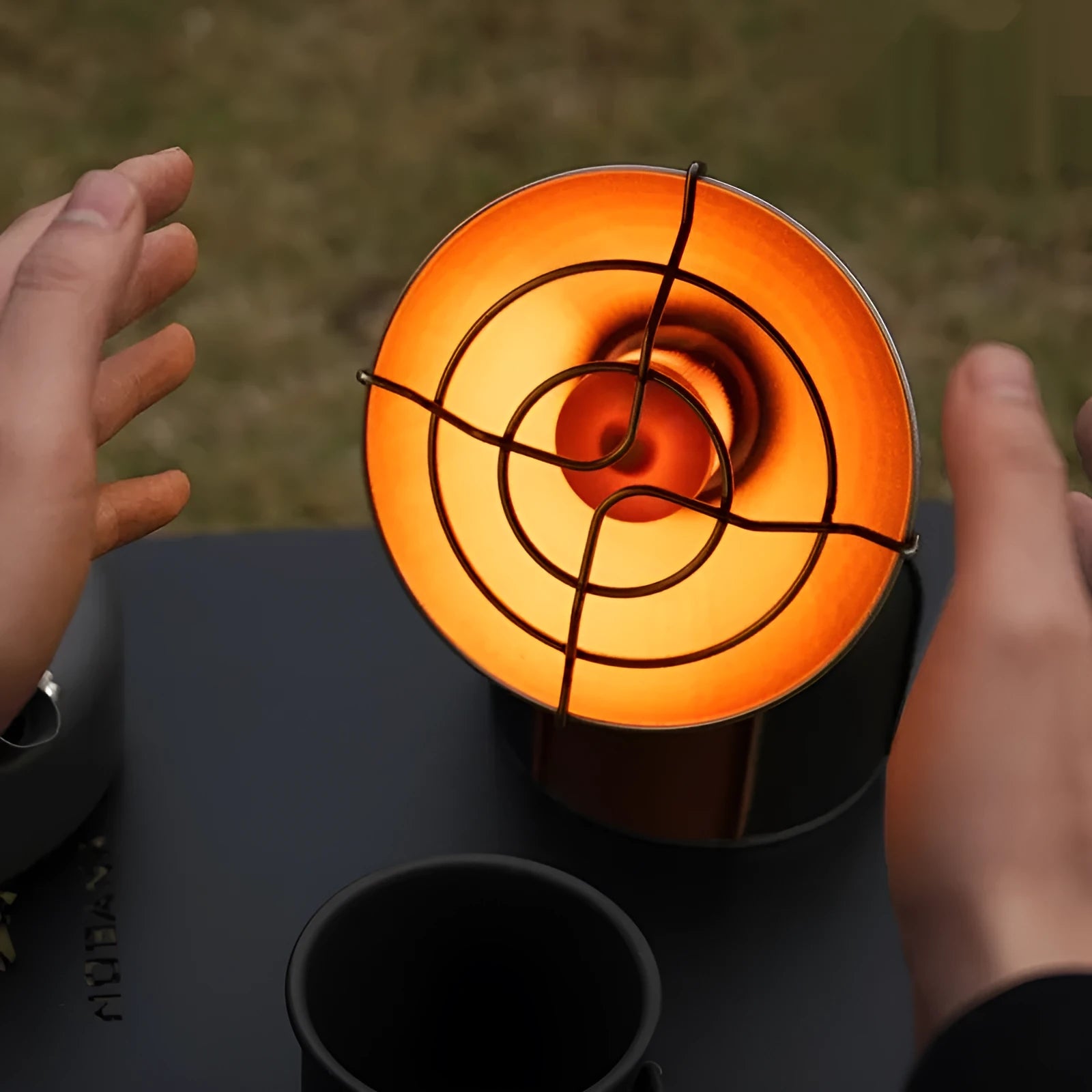 Portable outdoor heating stove with black and orange finish and automatic press ignition