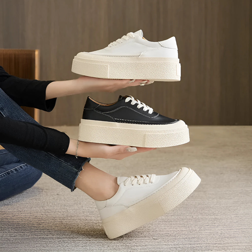 Women's black embossed leather platform sports shoes with round toe and white rubber sole on a white background.