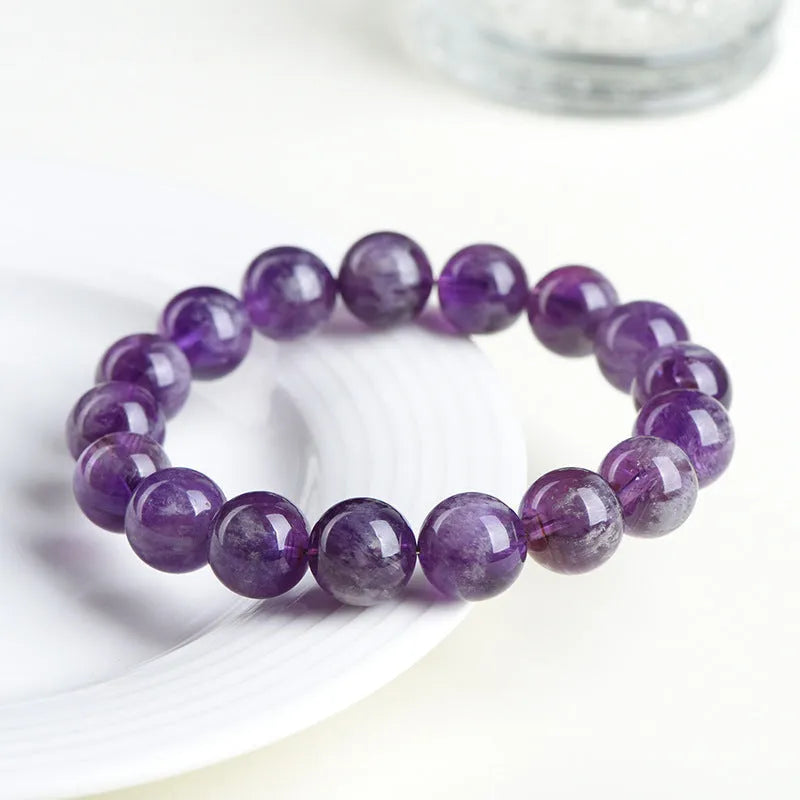 Natural Feather Amethyst Ruyi crystal bracelet with scattered geometry beads on a wrist.