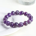 Natural Feather Amethyst Ruyi crystal bracelet with scattered geometry beads on a wrist.