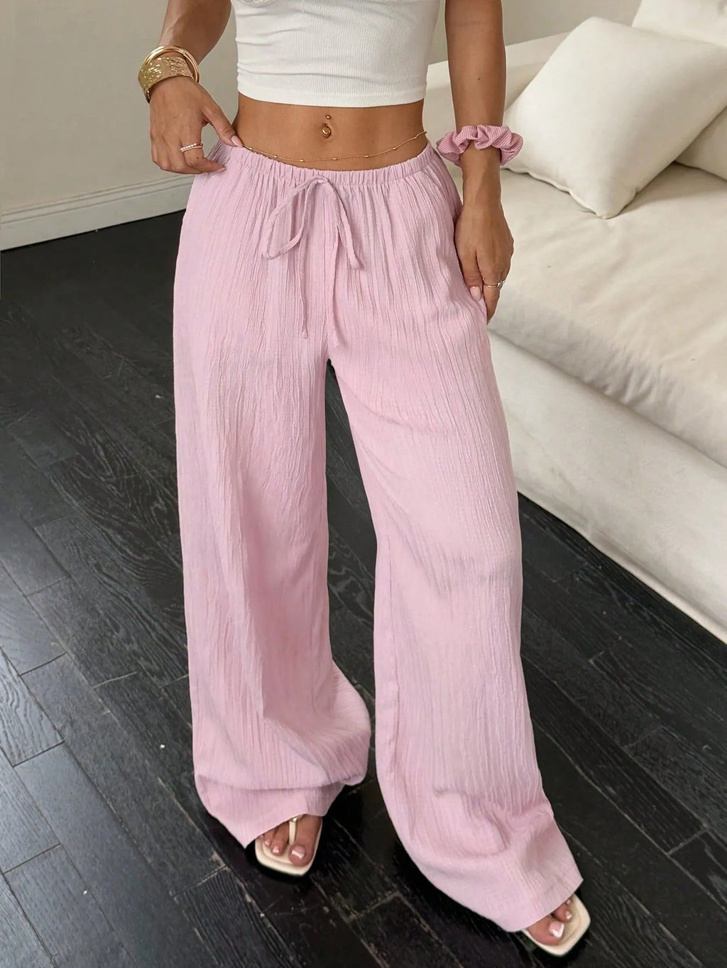 Women's black wide-leg trousers with lace-up waist detail and flowy silhouette