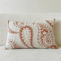 Jacquard woven paisley pattern pillow cover in amber colours on a sofa.