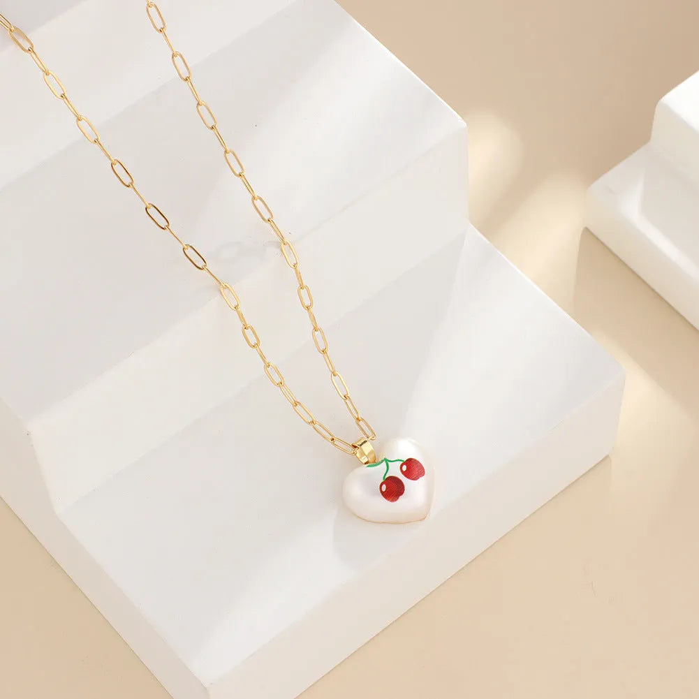 Adjustable chain necklace with a choice of geometric fruit pendant charms: apple, cherry, pear, pineapple, or strawberry.