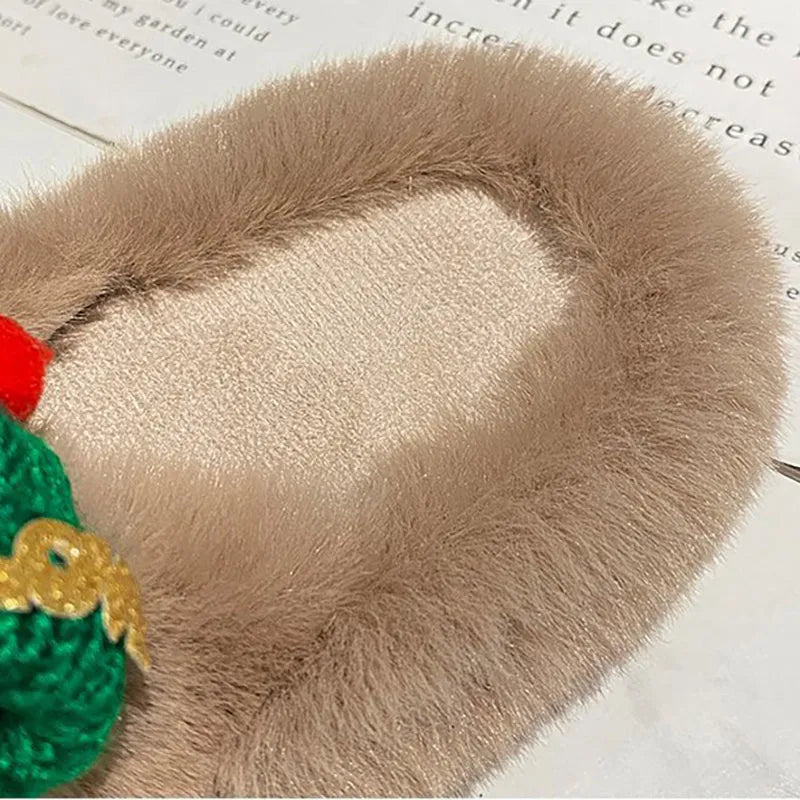 Women's black Christmas slippers with a large hairy decoration on the front, showing faux plush upper.