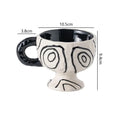 Hand-pinched irregular shaped ceramic mug in a solid colour on a table