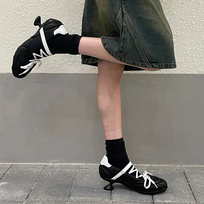 Women's silver lace-up sports shoes with a bow detail and a round toe, shown on a low-top cut.