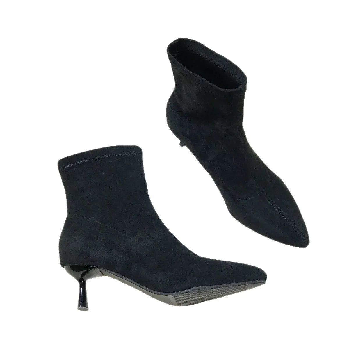 Black women's pointed toe Martin ankle boots with a high stiletto heel on a model.