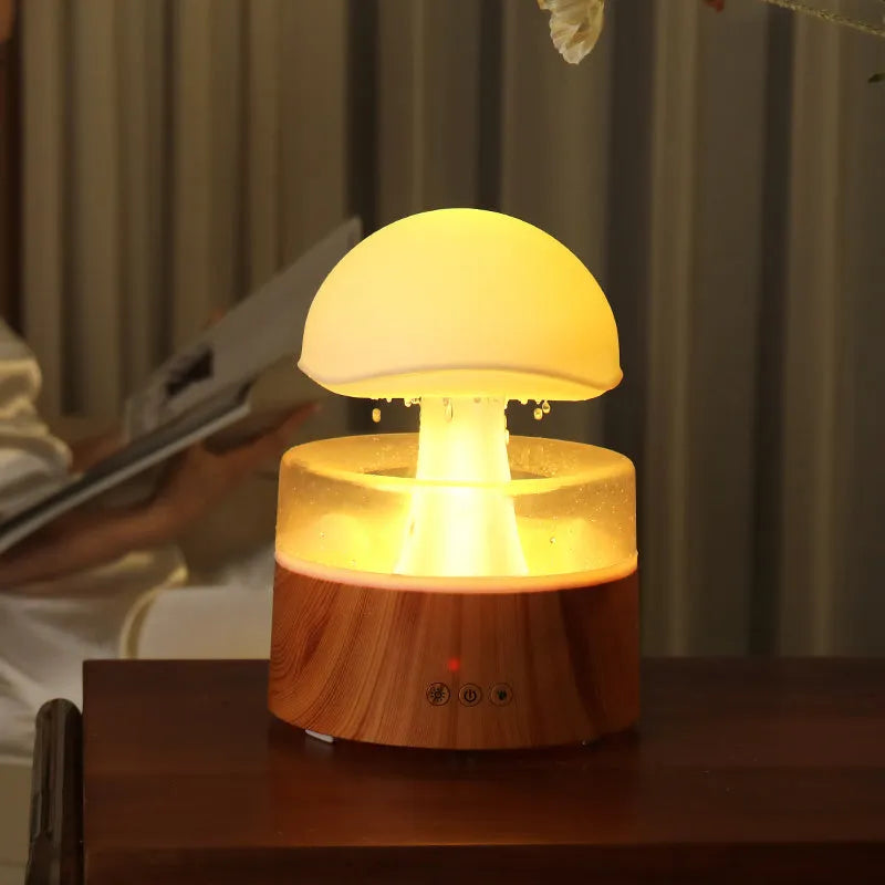 White cloud-shaped humidifier with LED lighting and raindrop simulation on wooden surface