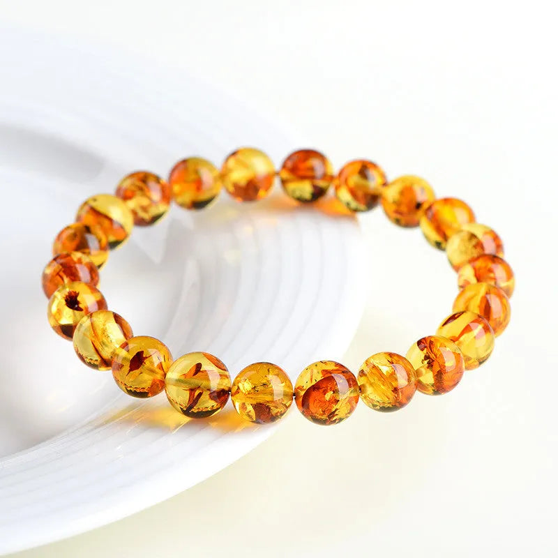 Natural yellow piebald amber beaded bracelet with geometric polished beads on a white background.