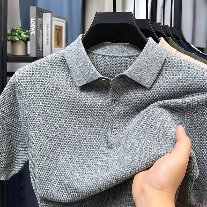 Loose-fitting short sleeve cotton pullover sweater in a neutral colour on a hanger.